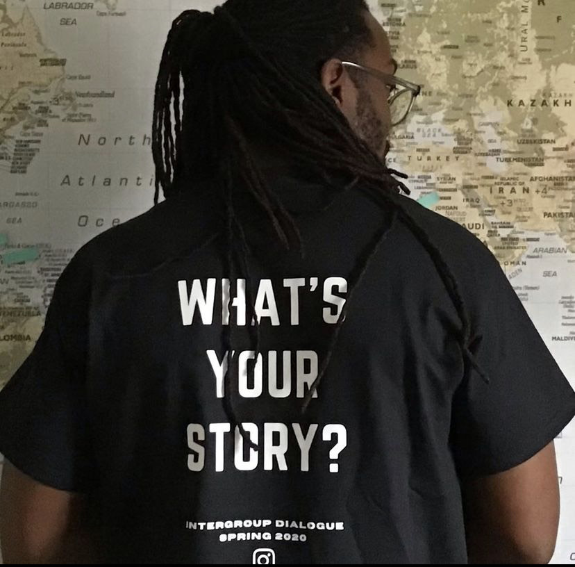 image of Easton wearing a black t-shirt with white font saying, "what's your story?" 